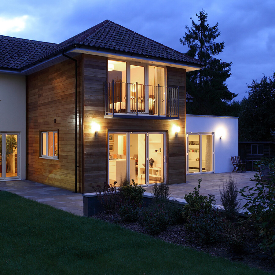 Image shows the outside of a house in the evening. Image depicts SureBuild Homes as experienced builders in Hitchin.