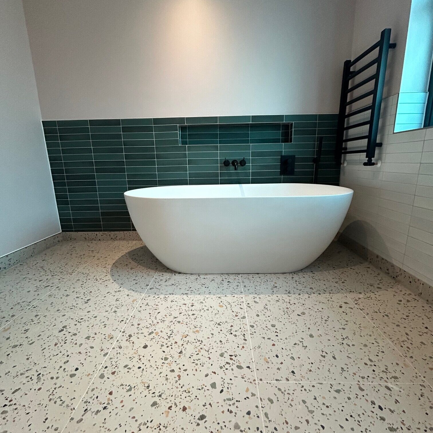 Image shows a bath in a newly installed bathroom