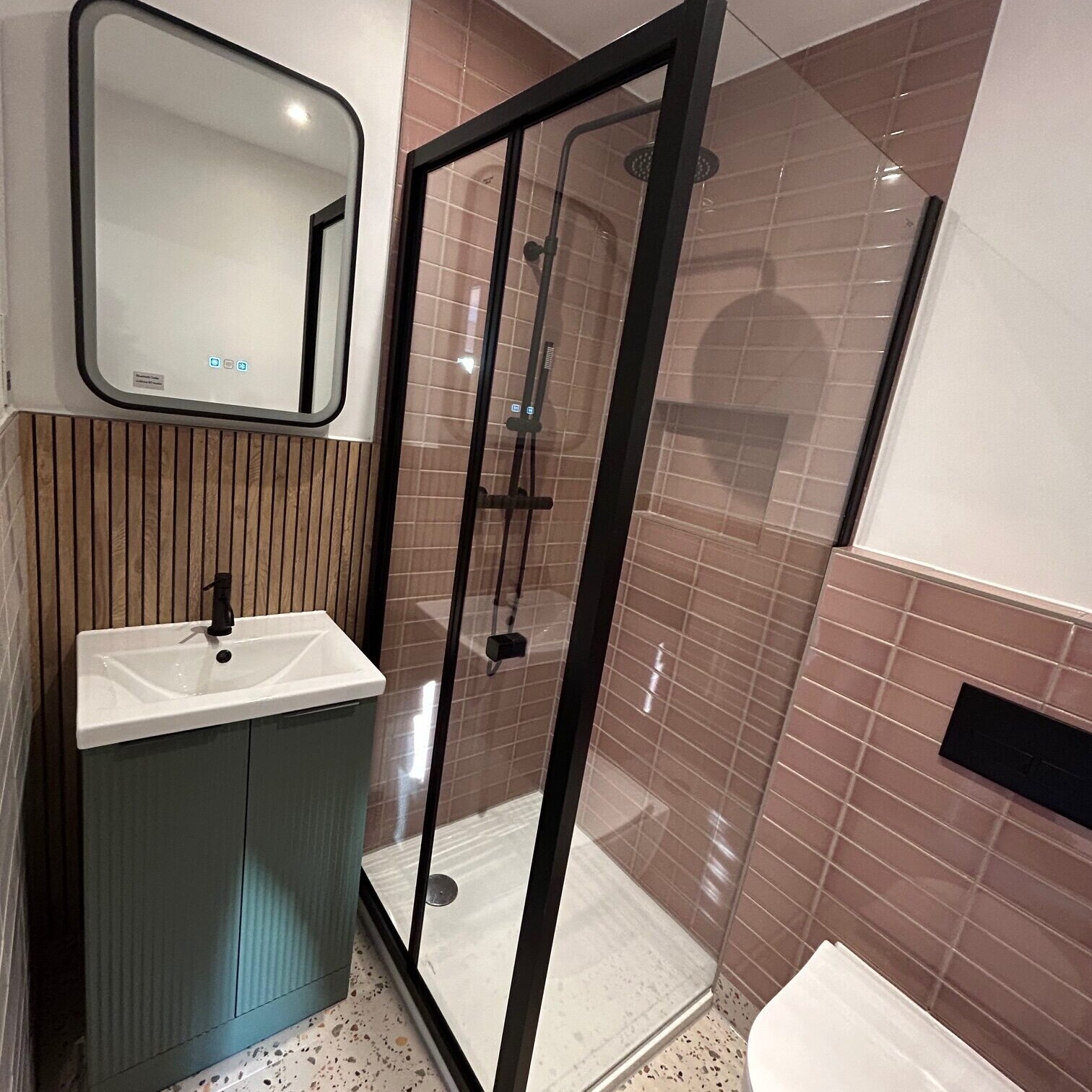 Image shows a shower, sink and toilet that have been newly fitted